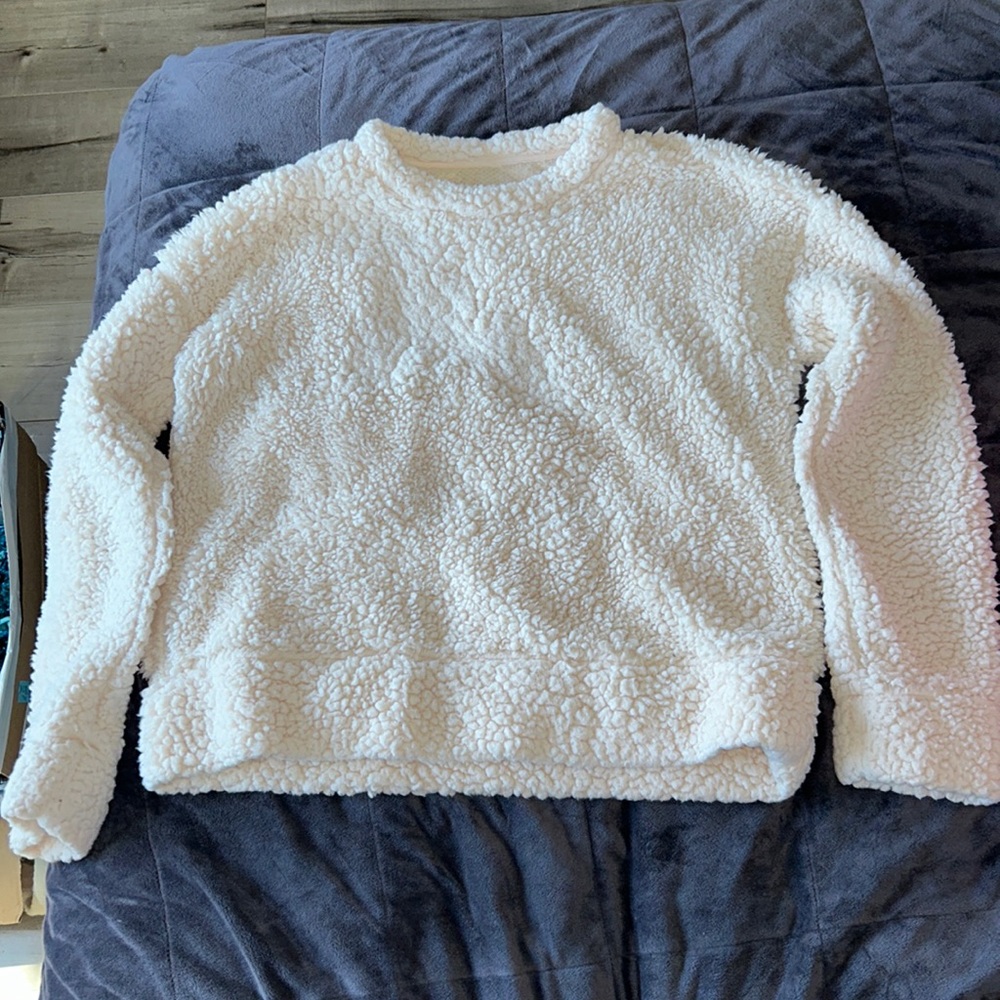 A small, cream colored, fluffy sweatshirt. Good for cold weathers